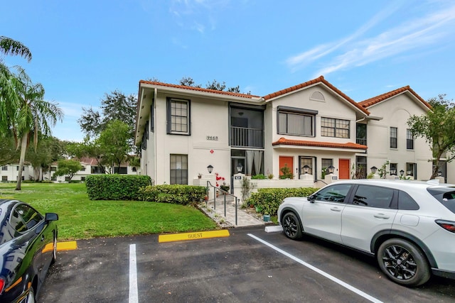 9668 Sills Dr Unit 101, Boynton Beach, FL 33437 - multi unit property with uncovered parking, a tile roof, stucco siding, and a front lawn