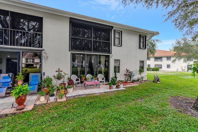 rear view of property featuring a lawn and a patio area