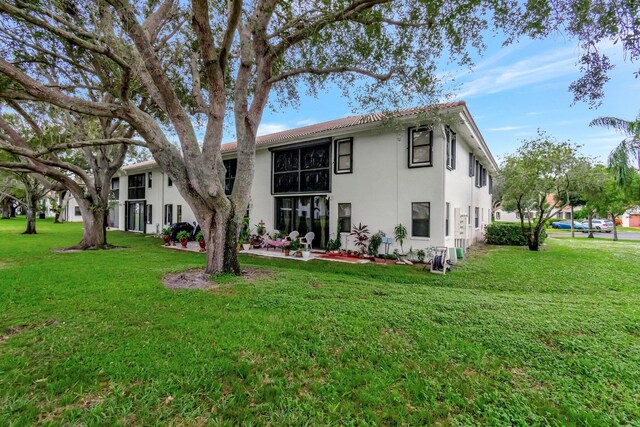 9668 Sills Dr Unit 101, Boynton Beach, FL 33437 - rear view of property with stucco siding, a yard, and a patio area