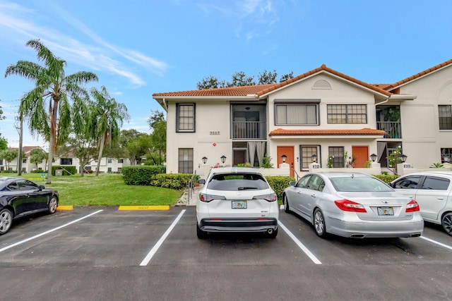 9668 Sills Dr Unit 101, Boynton Beach, FL 33437 - townhome / multi-family property featuring a tile roof, uncovered parking, stucco siding, and a front yard