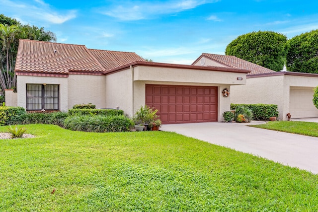 mediterranean / spanish home with a front yard and a garage