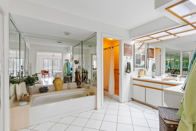 bathroom with a tub to relax in, tile patterned flooring, and vanity