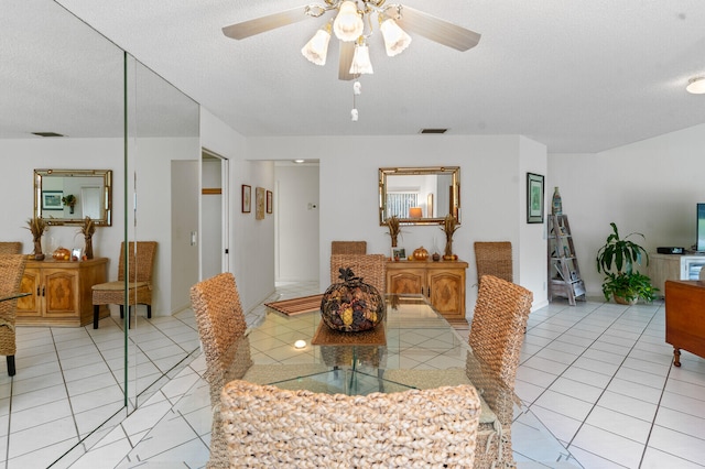 dining room featuring ceiling fan, light tile patterned floors, and a textured ceiling