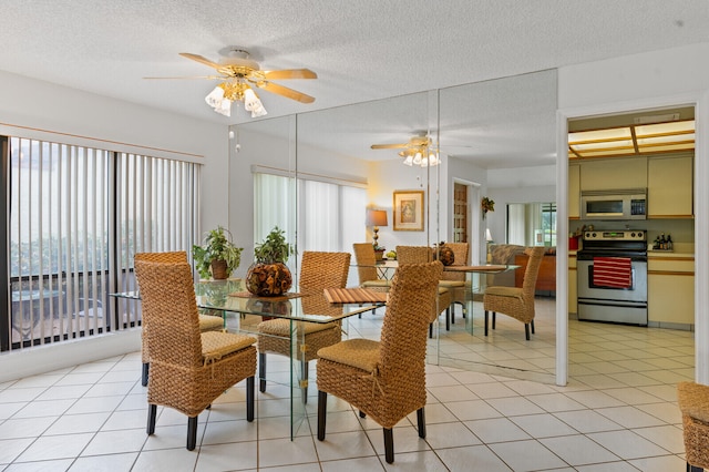 dining space with ceiling fan, light tile patterned floors, and a textured ceiling