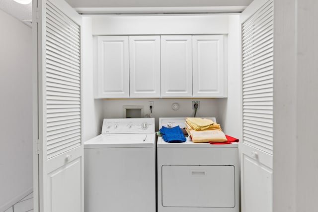 clothes washing area with cabinets and washing machine and dryer