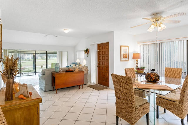 dining room featuring a textured ceiling, ceiling fan, lofted ceiling, and light tile patterned flooring