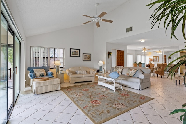 living room with ceiling fan, light tile patterned floors, and high vaulted ceiling