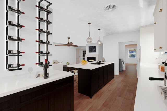 kitchen with a center island, sink, hanging light fixtures, hardwood / wood-style flooring, and ceiling fan