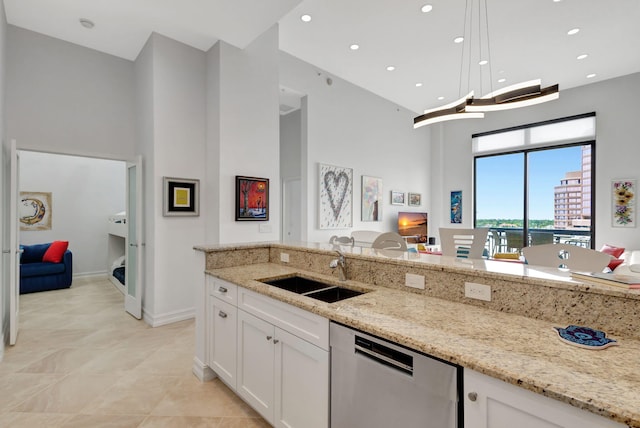 kitchen with light stone counters, sink, pendant lighting, dishwasher, and white cabinetry