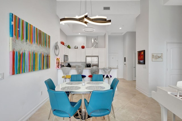 tiled dining area featuring a high ceiling