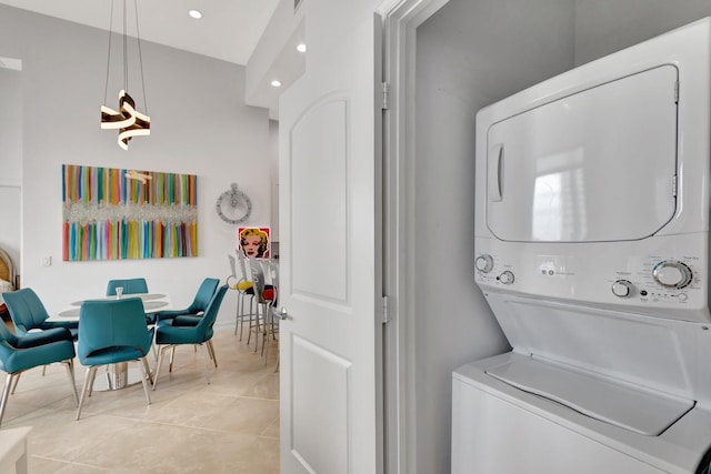 laundry area featuring light tile patterned floors and stacked washer and dryer