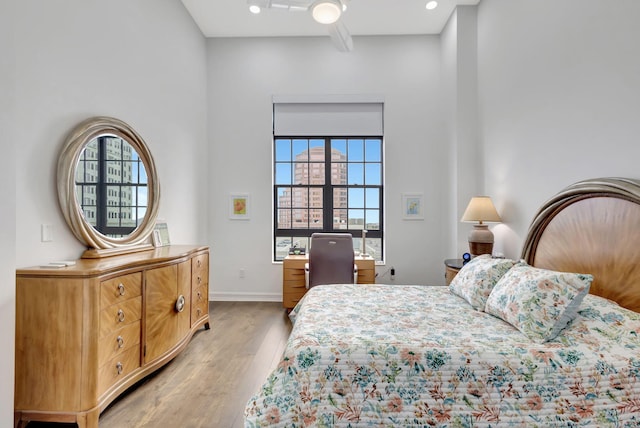 bedroom featuring multiple windows, ceiling fan, and light hardwood / wood-style flooring