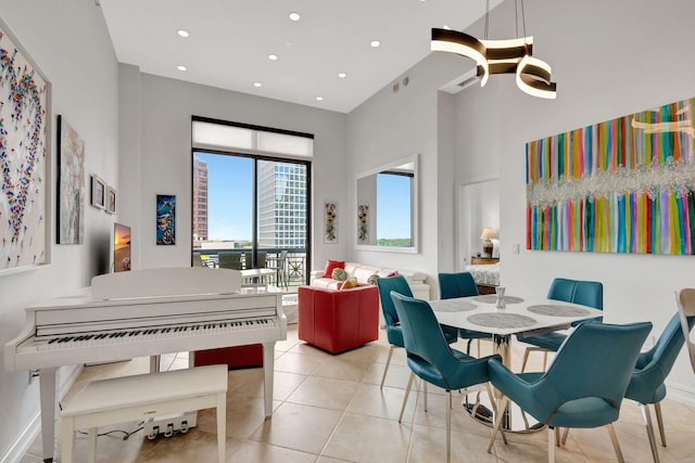 dining space with light tile patterned flooring and a high ceiling