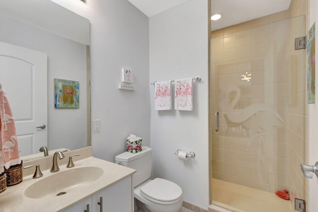 bathroom featuring a shower with door, vanity, and toilet