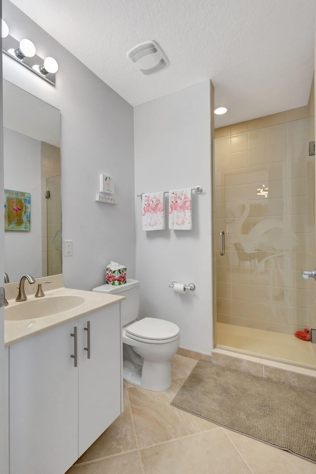 bathroom with tile patterned flooring, a textured ceiling, toilet, vanity, and a shower with shower door