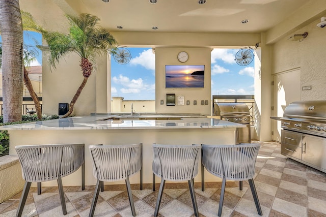 view of patio with exterior bar, a grill, and exterior kitchen