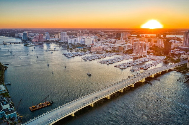 aerial view at dusk featuring a water view