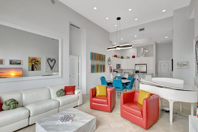 living room featuring a towering ceiling and light tile patterned flooring