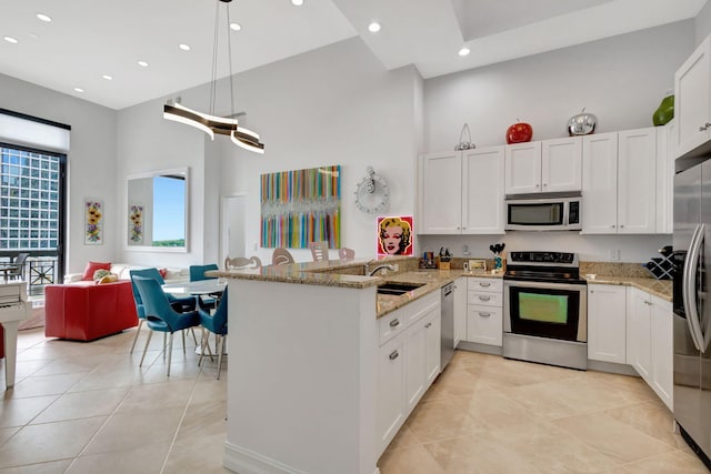 kitchen featuring kitchen peninsula, white cabinetry, high vaulted ceiling, and stainless steel appliances