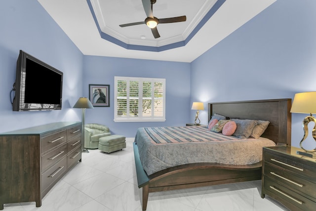 bedroom featuring marble finish floor, a ceiling fan, a raised ceiling, and crown molding