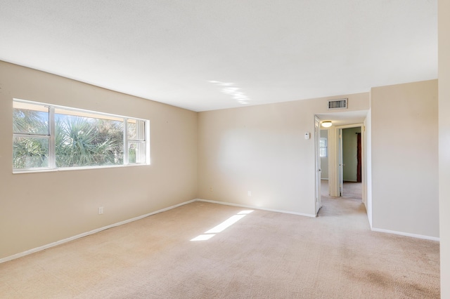 unfurnished room featuring light carpet