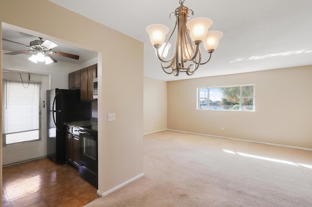 kitchen featuring dark carpet, ceiling fan with notable chandelier, hanging light fixtures, and black appliances