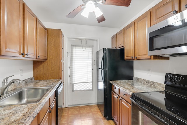 kitchen with sink, black appliances, ceiling fan, and light stone countertops