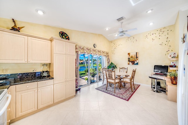 tiled dining area featuring ceiling fan and vaulted ceiling