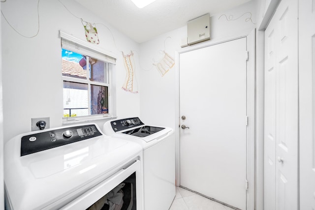 washroom featuring light tile patterned floors, a textured ceiling, and separate washer and dryer