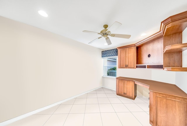 unfurnished office featuring ceiling fan and built in desk