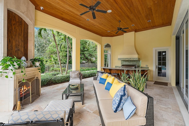 view of patio featuring ceiling fan, exterior kitchen, and an outdoor fireplace