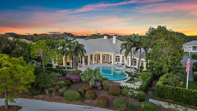 back house at dusk with french doors and a patio