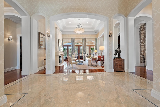 entryway featuring a raised ceiling, crown molding, and french doors