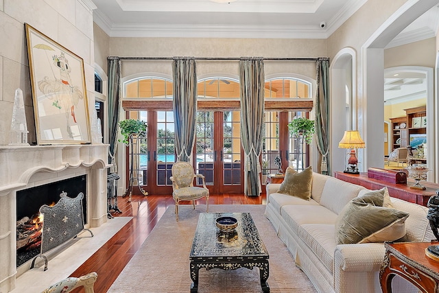 living room featuring a fireplace, french doors, hardwood / wood-style floors, and ornamental molding