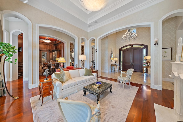 living room featuring a chandelier, a high ceiling, dark hardwood / wood-style flooring, and crown molding