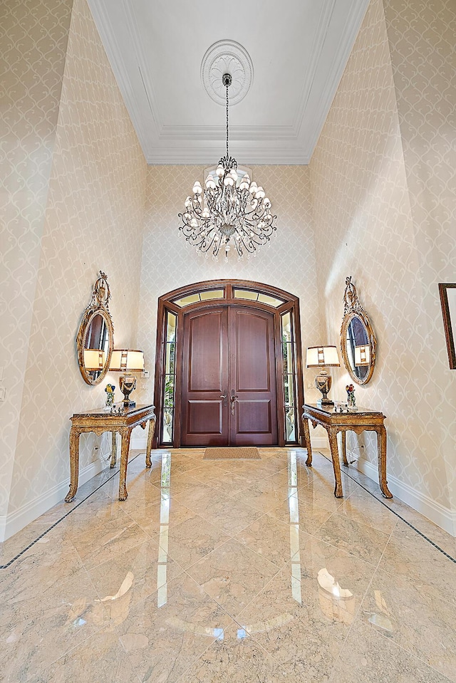 foyer featuring ornamental molding and an inviting chandelier