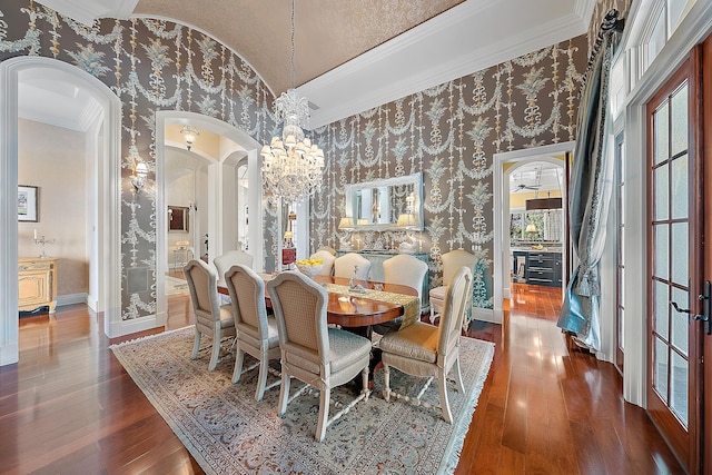 dining area featuring lofted ceiling, crown molding, a chandelier, and dark hardwood / wood-style floors