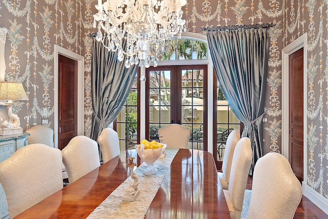 dining room with french doors, dark wood-type flooring, and an inviting chandelier