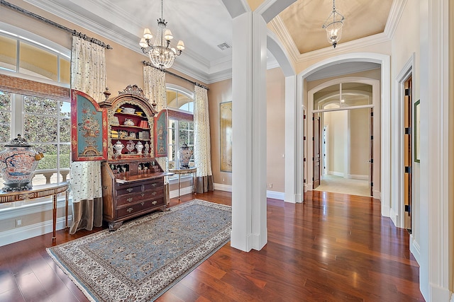 interior space featuring wood-type flooring, an inviting chandelier, a wealth of natural light, and crown molding