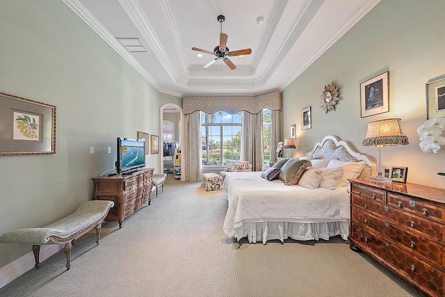 bedroom featuring ceiling fan, a raised ceiling, crown molding, and light carpet