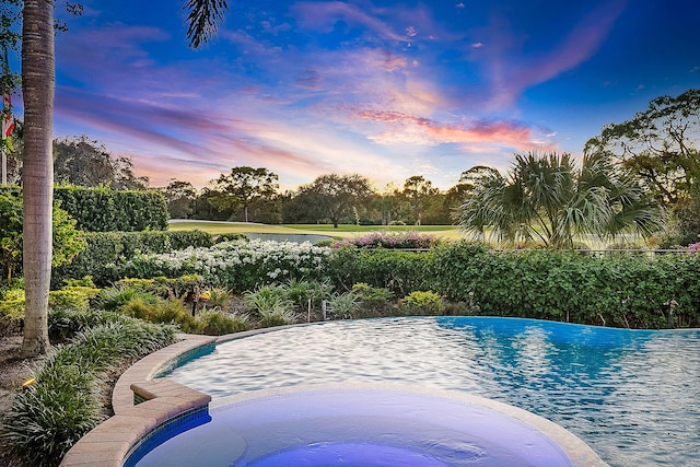 view of pool at dusk