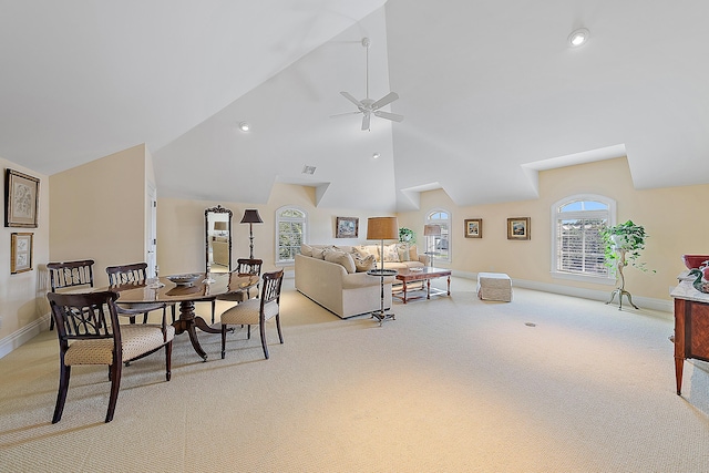 carpeted living room with ceiling fan and high vaulted ceiling