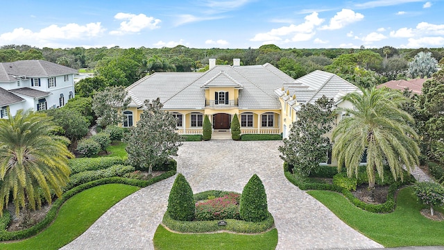 view of front of property featuring a porch, a balcony, and a front lawn