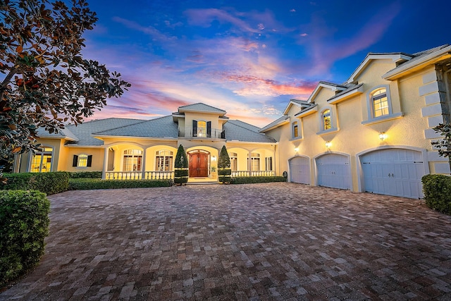 view of front of house featuring covered porch, a balcony, and a garage