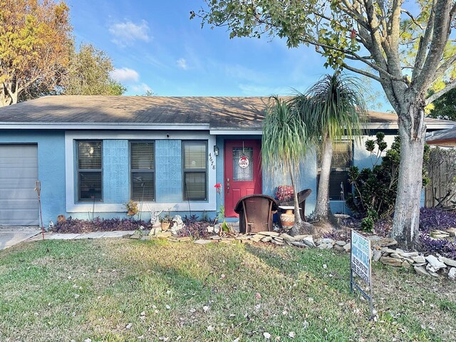 single story home with a front yard and a garage