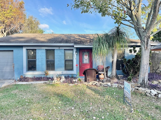 ranch-style home with a garage and a front lawn