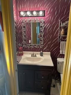 bathroom featuring tile patterned flooring, vanity, and toilet