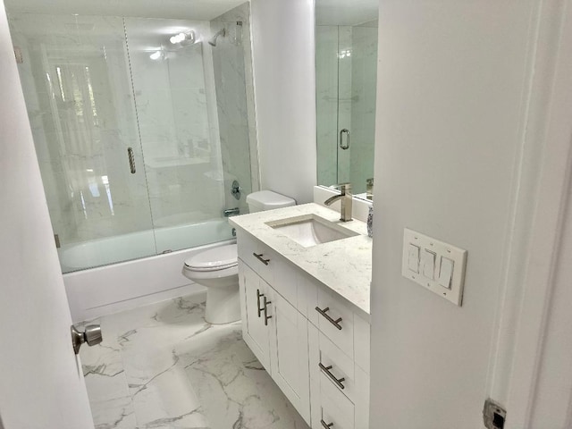 full bathroom featuring vanity, bath / shower combo with glass door, and toilet