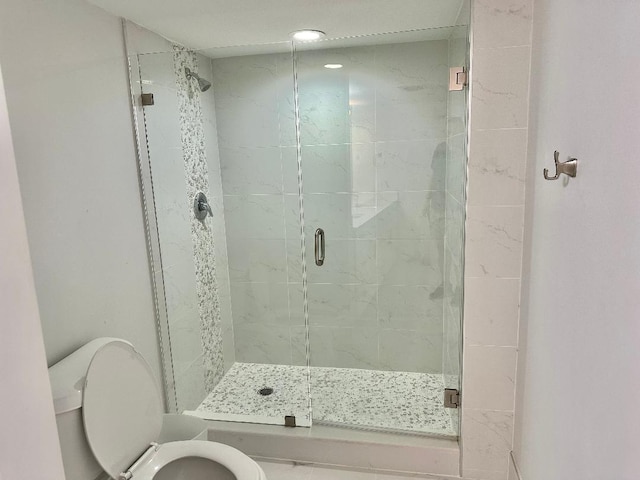 bathroom featuring walk in shower and toilet