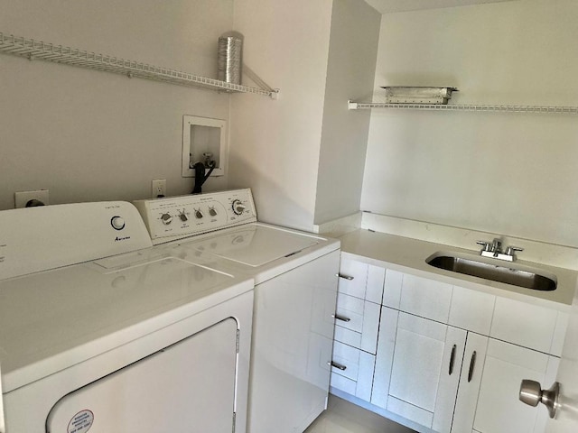 laundry area with washer and clothes dryer, cabinets, and sink